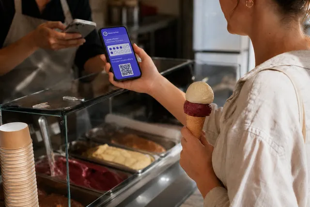 Carte de fidélité à tampons digitale sur un smartphone, présentée au comptoir d'un glacier pour être scannée
